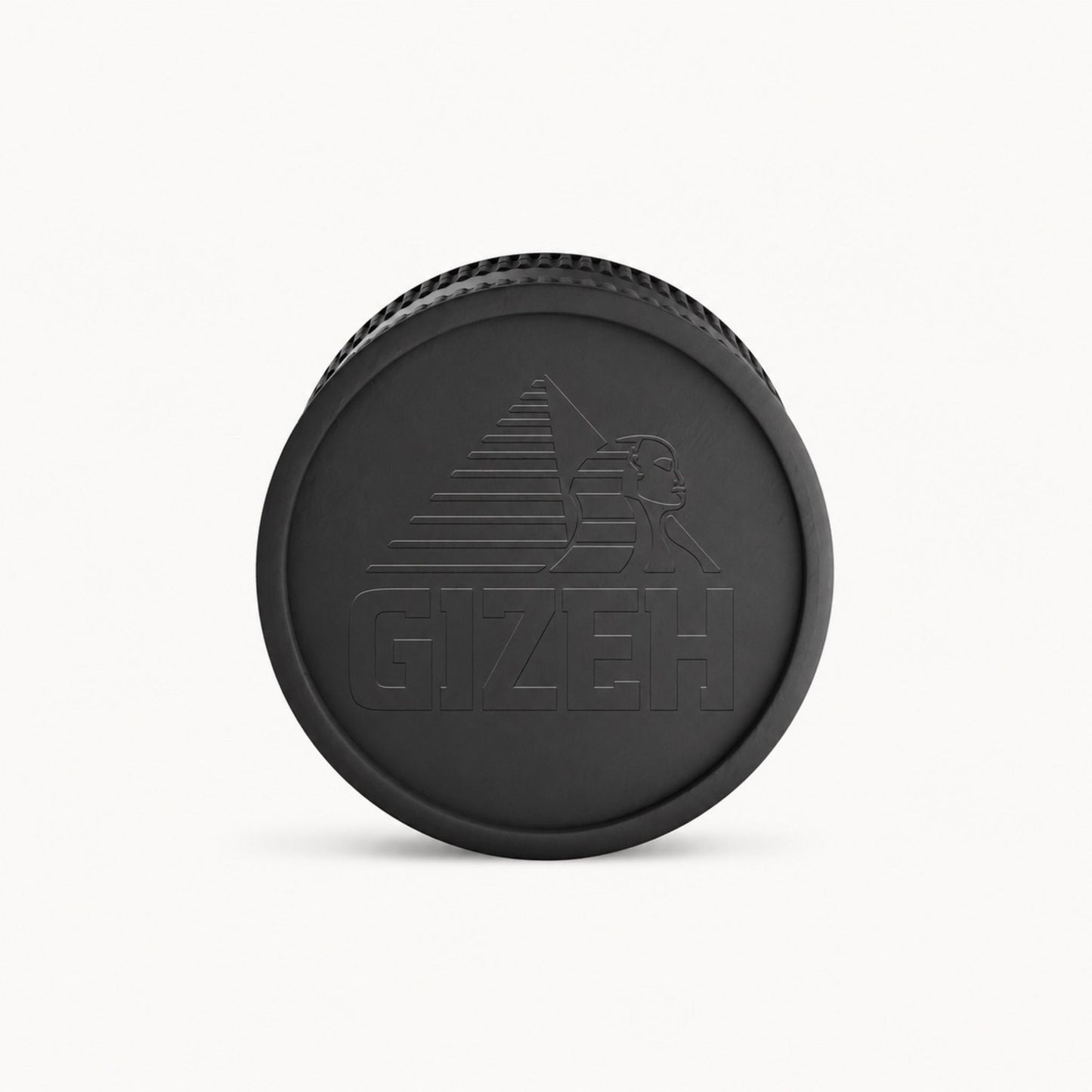 Schwarzer GIZEH Grinder Deckel mit geprägtem Logo auf hellem Hintergrund.