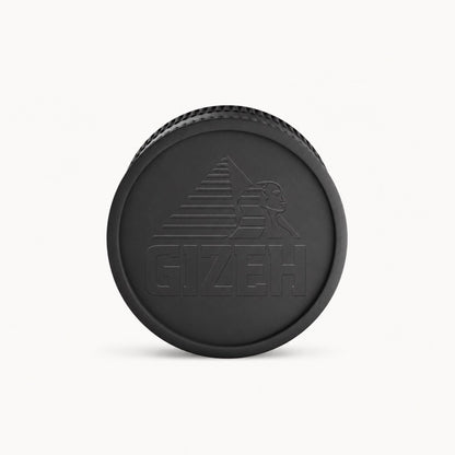 Schwarzer GIZEH Grinder Deckel mit geprägtem Logo auf hellem Hintergrund.