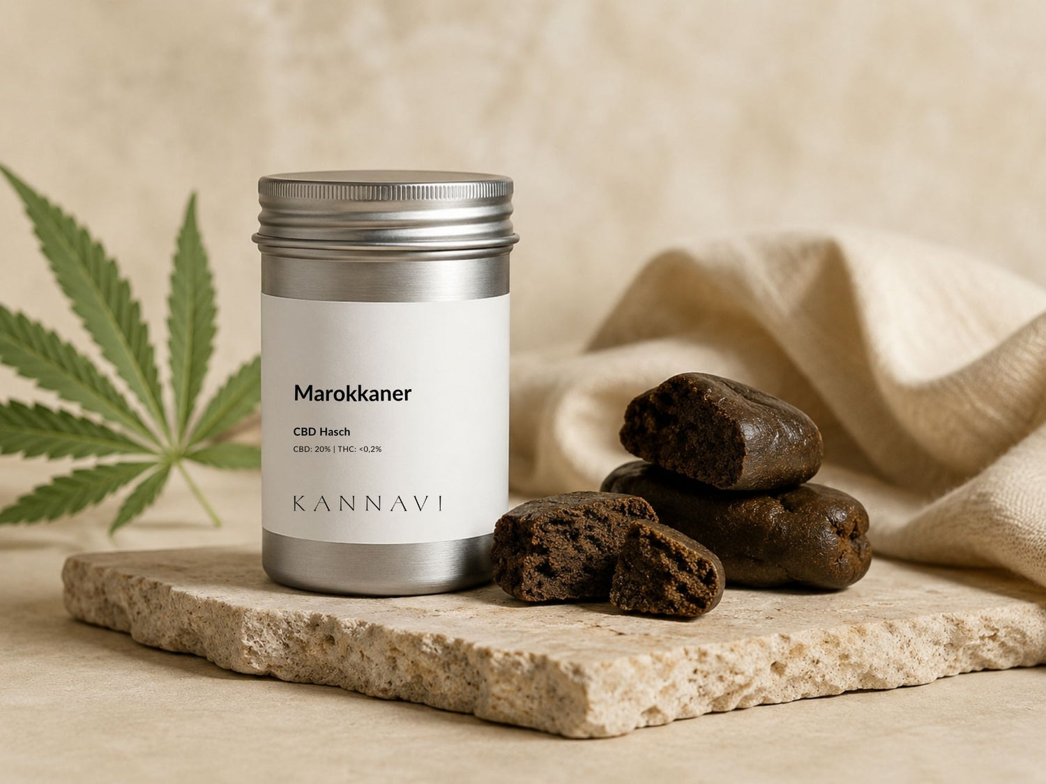 CBD Hasch Marokkaner in silberner Dose mit Haschstücken und Hanfblatt auf heller Natursteinplatte