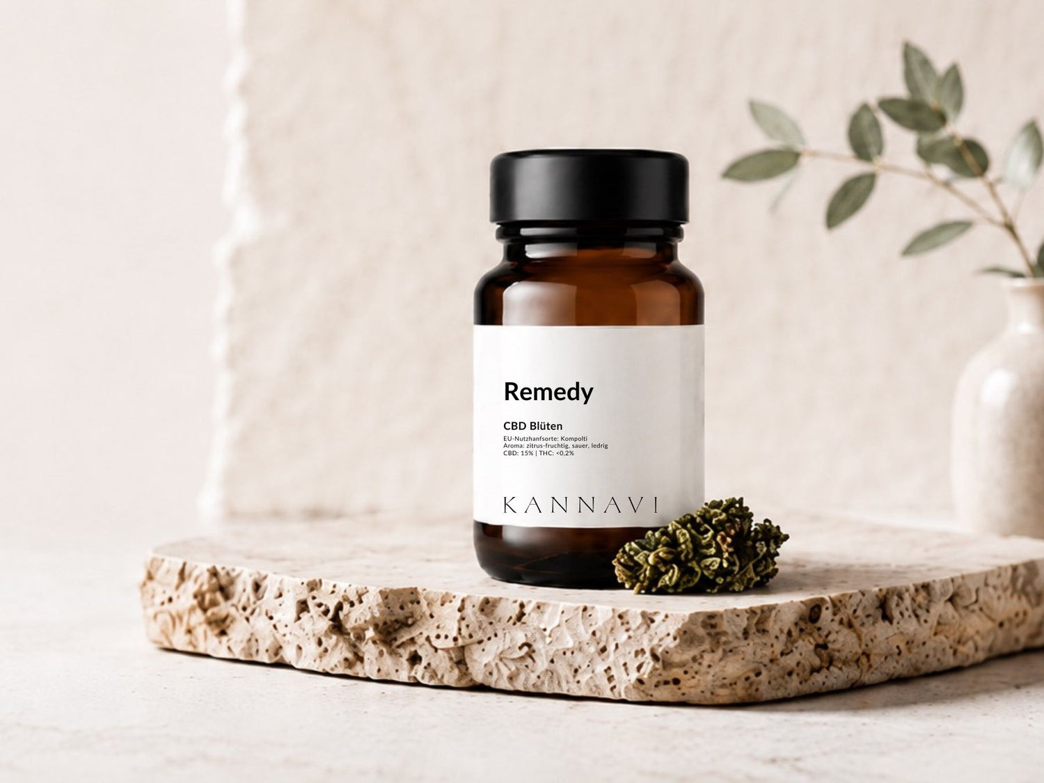 Kannavi Remedy CBD Blüten im braunen Glas auf Natursteinplatte mit Hanfblüte und heller Deko