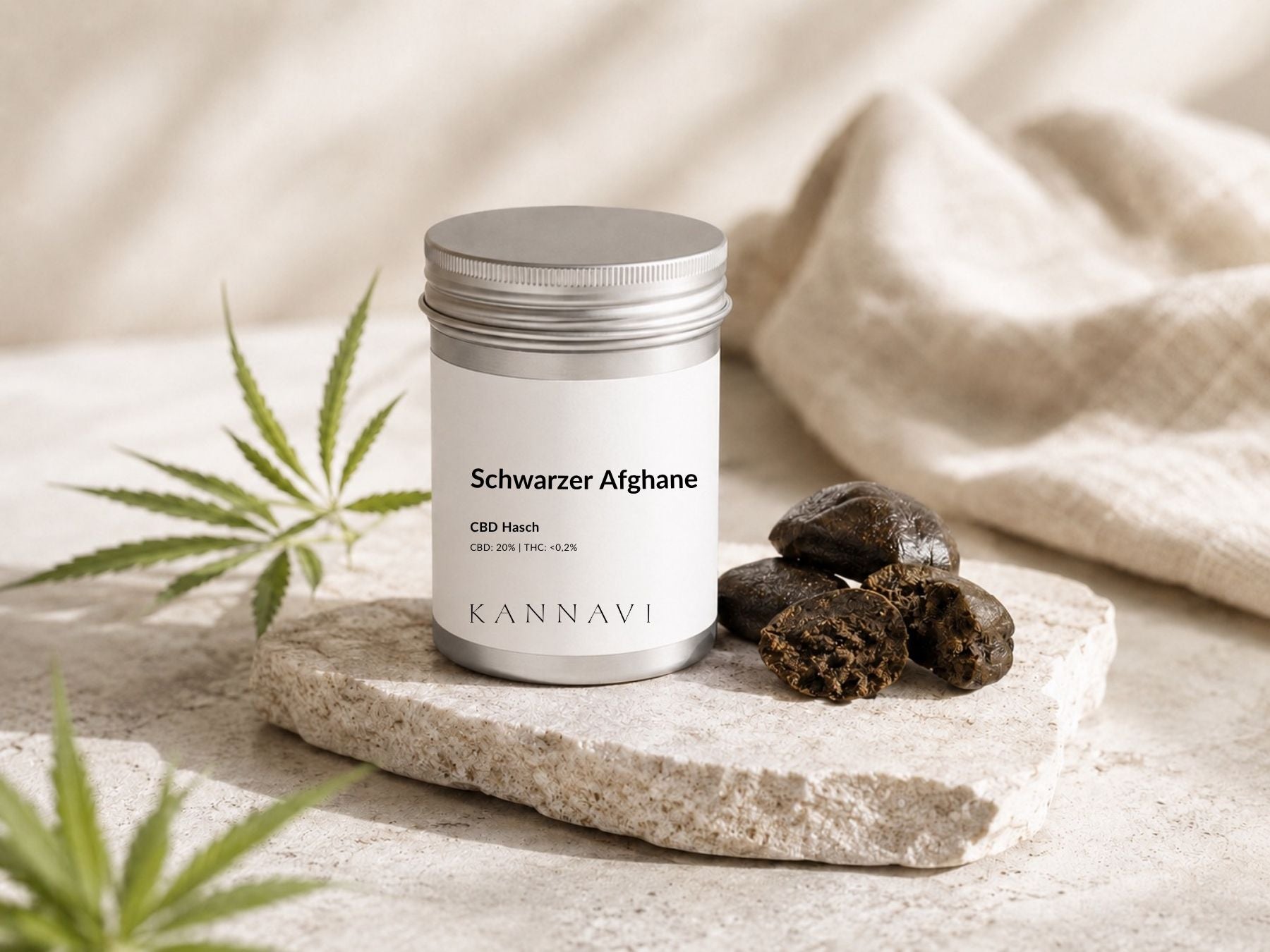 Kannavi Schwarzer Afghane CBD Hasch in silberner Dose mit Haschstücken und Hanfblatt auf Naturstein
